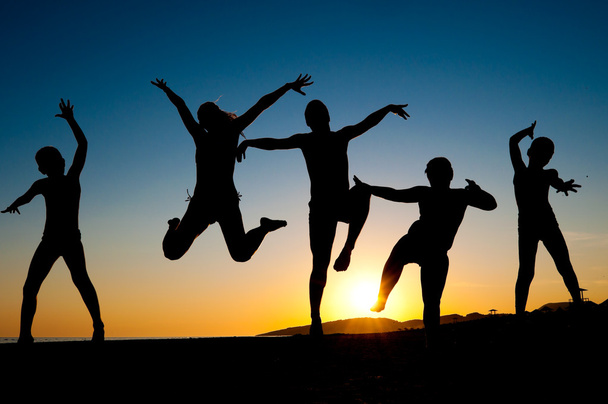 siluetas de niños felices saltando en la playa
 - Foto, Imagen