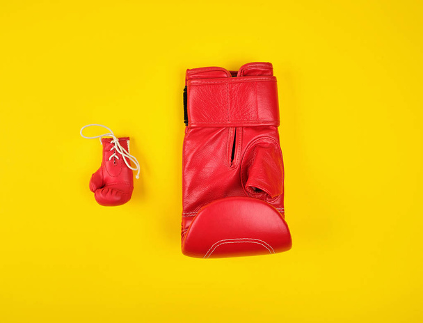 две красные боксерские перчатки на желтом фоне
 - Фото, изображение