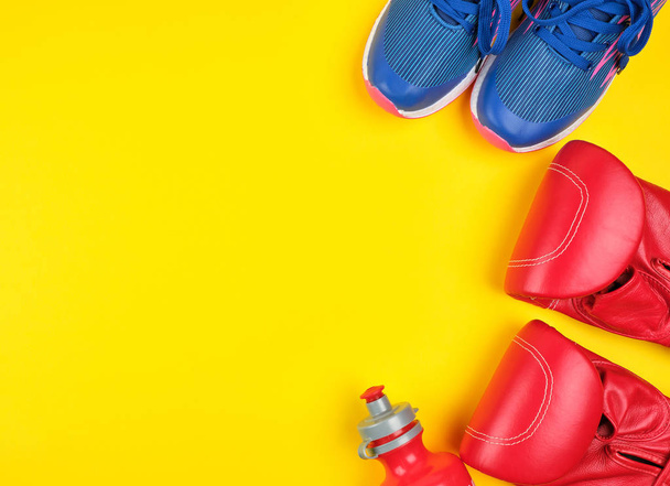 kırmızı boks eldiven ve mavi spor ayakkabı çifti - Fotoğraf, Görsel