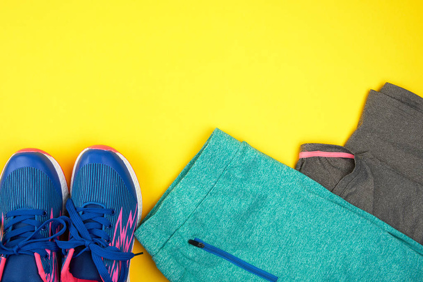sarı bir backgr spor için mavi kadın spor ayakkabıları ve giysileri - Fotoğraf, Görsel