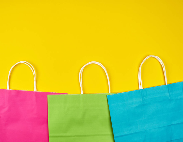 bolsas de compras rectangulares de papel multicolor con asas blancas
 - Foto, imagen