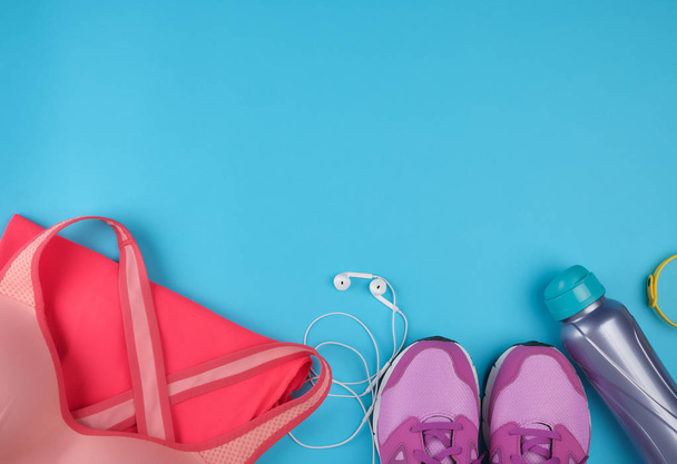 рожеві жіночі кросівки, пляшка води, одяг та бюстгальтери для дружини
 - Фото, зображення
