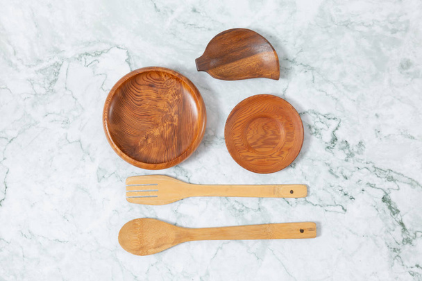 Flat lay top view of wooden spoons, wooden disk pattern on marbl - Fotografie, Obrázek