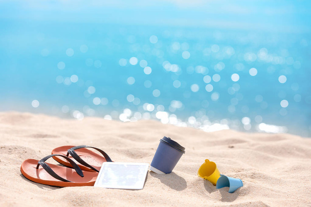 Akcesoria plażowe z filiżanką papieru do kawy i tabletem na plaży-Su - Zdjęcie, obraz