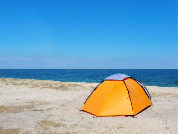 orange tent on the sand against the background of the sea and sky - Fotografie, Obrázek