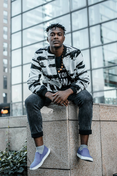 Портрет человека афро-американского привлекательного профиля на улице. Модный африканский мужчина в джинсовой куртке позирует в городе. Африканский американец в костюме
. - Фото, изображение