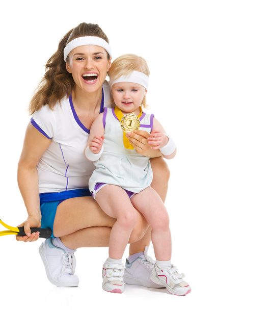Portrait of mother and baby in tennis clothes holding medal - Photo, image