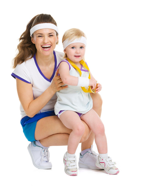 Portrait of mother and baby in tennis clothes with medal - Foto, afbeelding