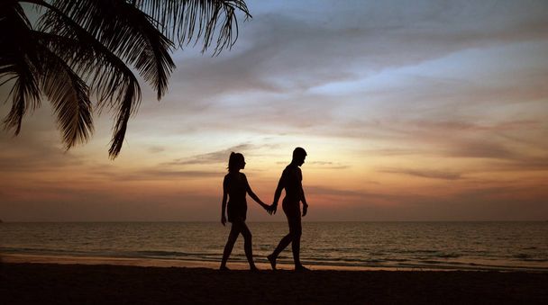 Couple attrayant relaxant et marchant sur une plage tropicale
 - Photo, image