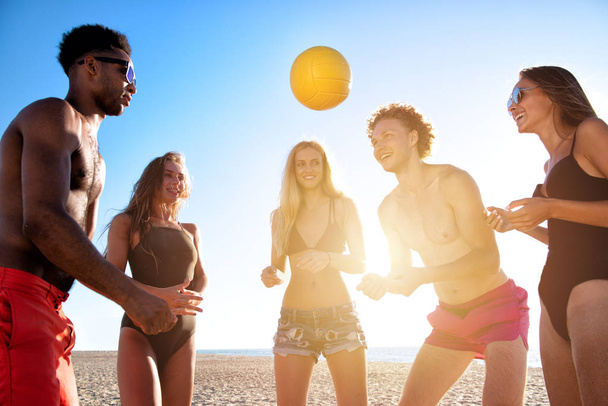Gruppo di amici che giocano a beach volley in spiaggia
 - Foto, immagini