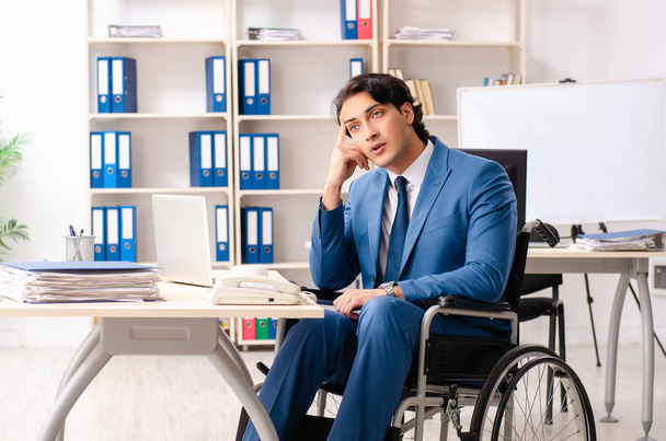 Male employee in wheelchair working at the office  - 写真・画像