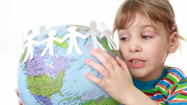 Girl holds globe with ribbon of paper cut manikins - Video, Çekim