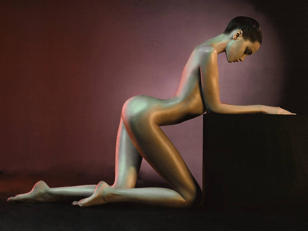 Elegant nude model in the light colored spotlights - Φωτογραφία, εικόνα