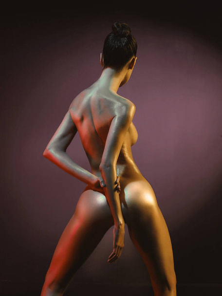 Elegant nude model in the light colored spotlights - Photo, Image