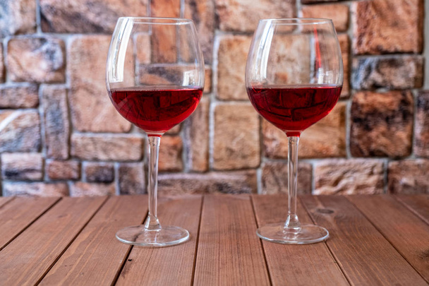 deux verres de vin rouge sur une table en bois - Photo, image