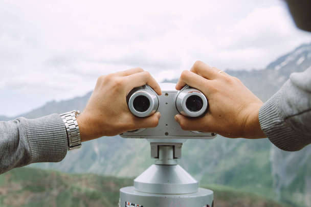 Person having a look through the tourist binoculars at Georgian mountains - Foto, Imagem