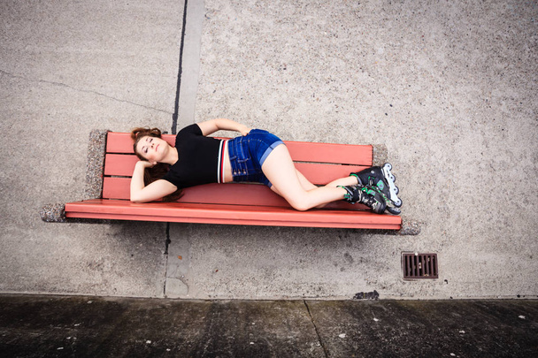 Crazy woman on bench wearing roller skates - Foto, Imagen