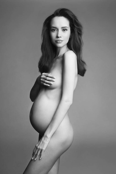 Studio fashion portrait of beautiful pregnant woman. - Фото, зображення