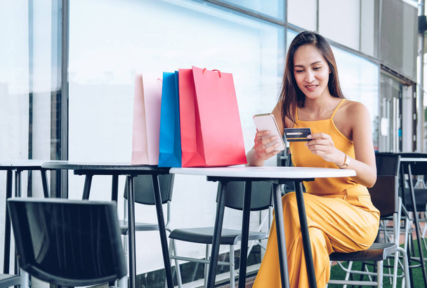 женщина держит мобильный смартфон и кредитную карту для онлайн-платёжников
 - Фото, изображение