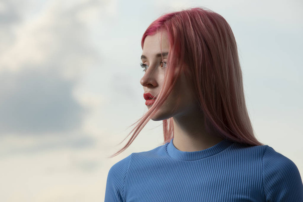 Unconventional woman portrait with pink hair against sky background - Foto, imagen