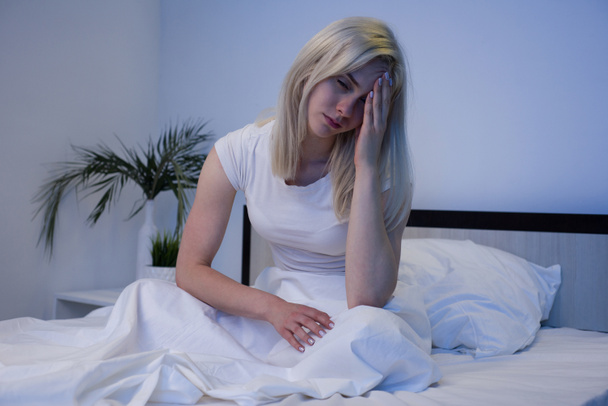 Депрессивная женщина бодрствует ночью, она истощена и страдает от бессонницы
 - Фото, изображение