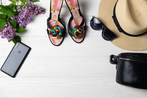 Belleza composición de moda con zapatos sombrero gafas de sol teléfono celular y flores
 - Foto, Imagen