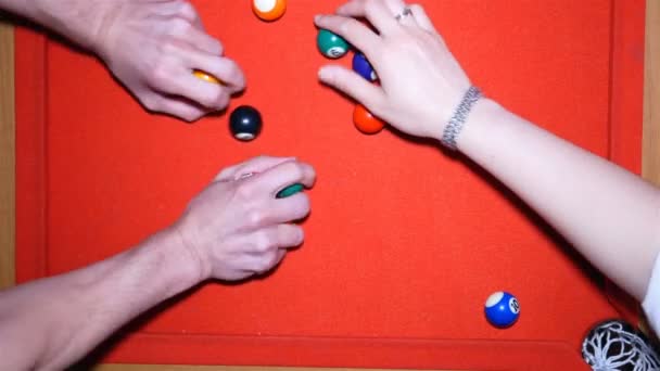 Billiards. Hands take balls of billiards.Billiard balls on the billiard table. Four hands take and point billiards balls to camera. Red table and multi-colored balls. - Footage, Video