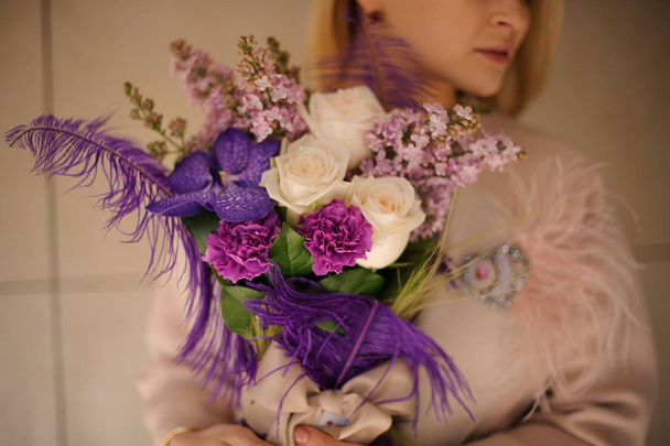 Girl holding a spring bouquet of tender pink and violet flowers - Photo, Image