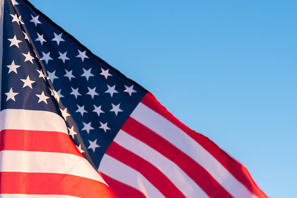 青空にアメリカ国旗を掲げ、クローズアップ。アメリカの7月4日の独立記念日のシンボル - 写真・画像