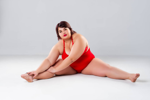 Plus size model in red lingerie, fat woman in underwear on gray background, body positive concept - Fotoğraf, Görsel