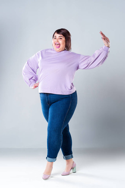 Happy plus size model in casual clothes, fat woman on gray background, body positive concept - Photo, Image