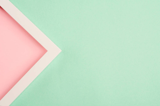 Pink triangle in a frame on a green background. Top view. Copy space - Φωτογραφία, εικόνα