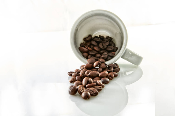 Coffee beans in a coffee cup isolated on white - 写真・画像