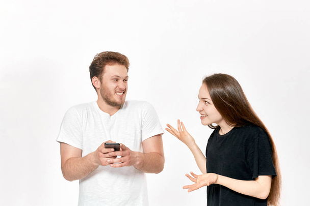 Studioaufnahme eines jungen Paares, das sich streitet. Frau ärgert sich, dass Mann ständig telefoniert, ohne auf sie zu achten. - Foto, Bild