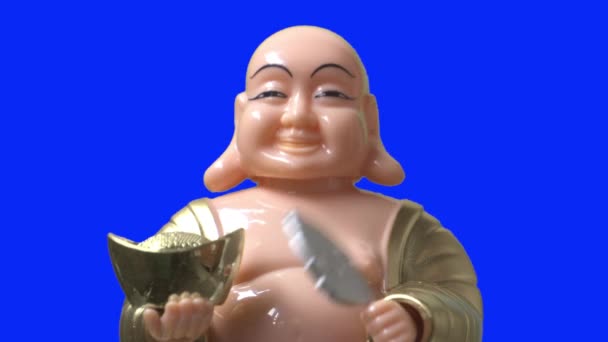 Mosolygó Buddha alak bólint, és fújja a hajtogató ventilátort. Közelről. Kék képernyő. - Felvétel, videó