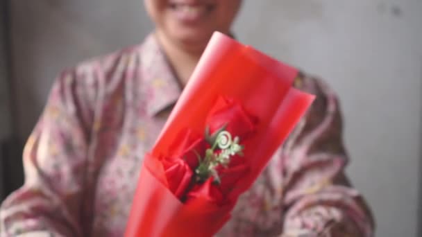 Aziatische Dame met glimlach geeft een boeket van een rode roos aan u. voor Love One. Aftelkalender voor Valentijnsdag. - Video