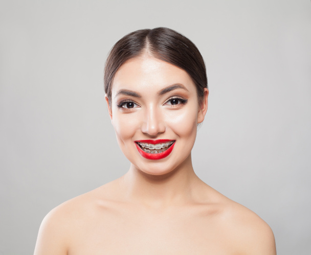 Smiling woman in braces on white background - 写真・画像