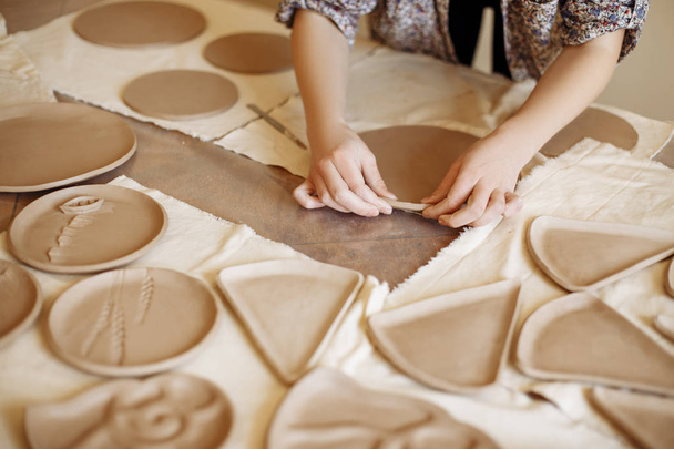 female hands set up clay plates - Фото, зображення