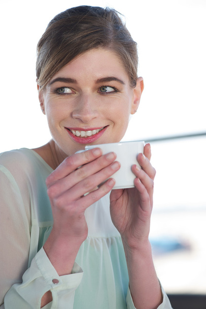 Jovem mulher bebendo uma xícara de café ao ar livre
 - Foto, Imagem