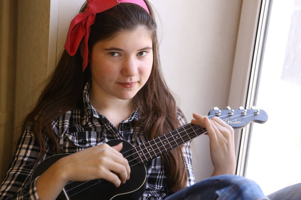 felice teen girl con chitarra ukulele in camicia a quadri e jeans p
 - Foto, immagini