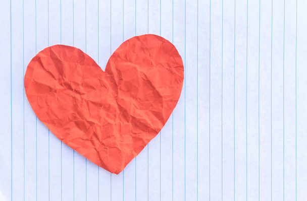 red paper heart over white sheet - Foto, Bild