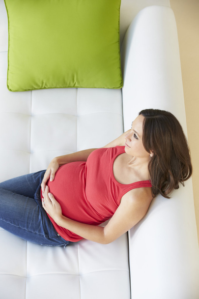 Overhead View Of Pregnant Woman Relaxing On Sofa - Φωτογραφία, εικόνα