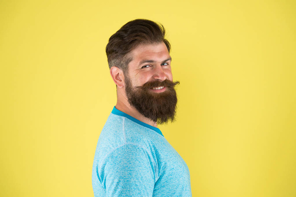 Bring your hair to the next level. Happy hipster with long beard and stylish hair on yellow background. Bearded man with unshaven face hair. Brutal guy with shaped beard and mustache hair - Photo, Image