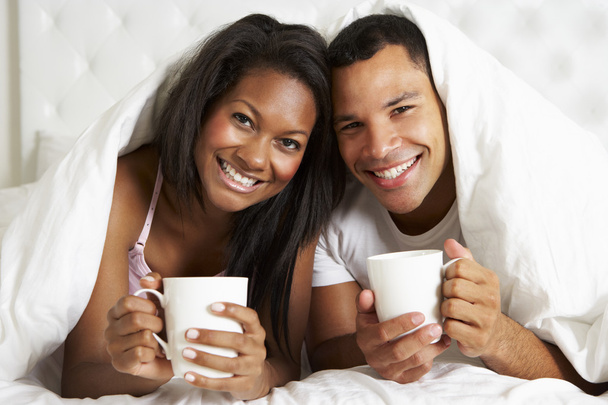Couple Relaxing In Bed With Hot Drink - 写真・画像