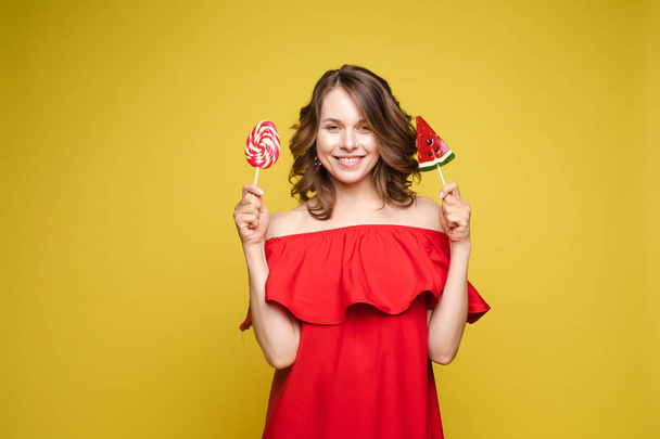Fashionable young woman with lolipop in her hands on background - Photo, Image