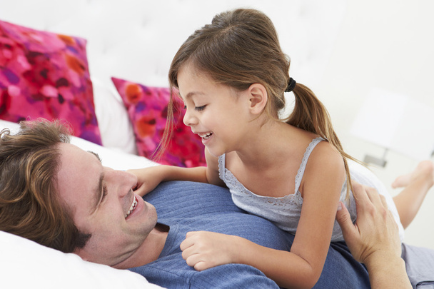 Father And Daughter Lying In Bed Together - Foto, Imagen