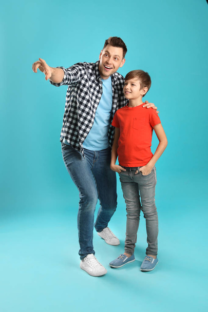 Portrait of dad and his son on color background - Photo, Image