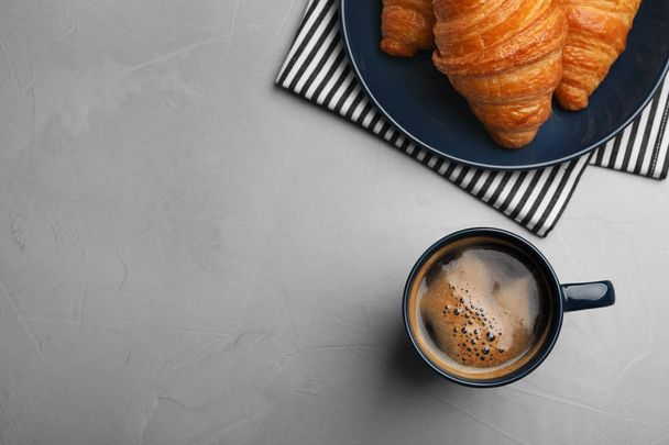 Flat lay composition with coffee and croissants on grey table, space for text - Фото, зображення