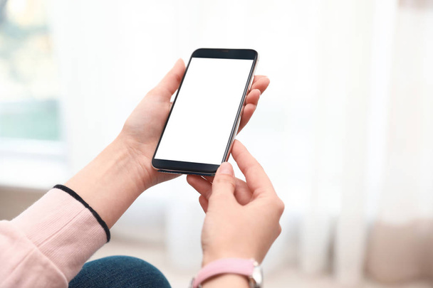 Femme tenant smartphone avec écran blanc à l'intérieur, gros plan des mains. Espace pour le texte
 - Photo, image