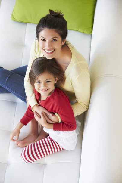 Overhead View Of Mother And Daughter Relaxing On Sofa - Foto, afbeelding